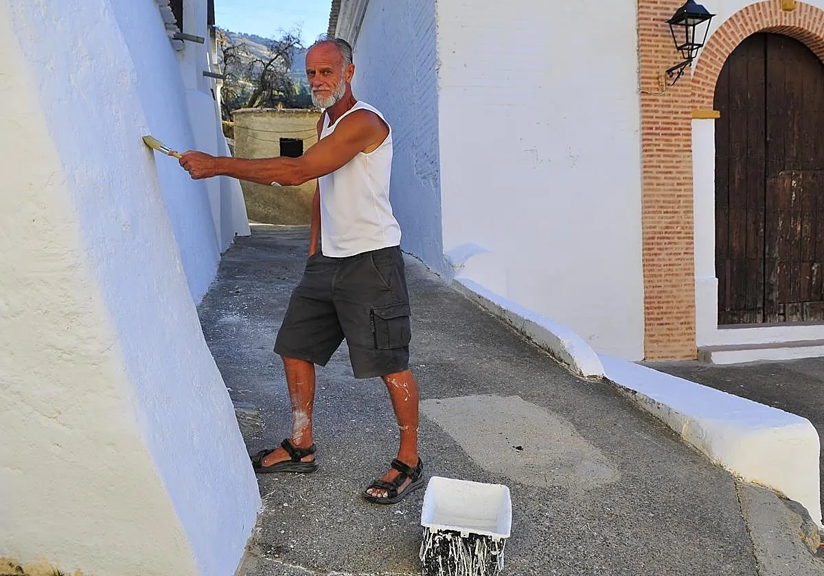Un vecino de Bayacas, en Órgiva, pinta de blanco gratis los muros del pueblo